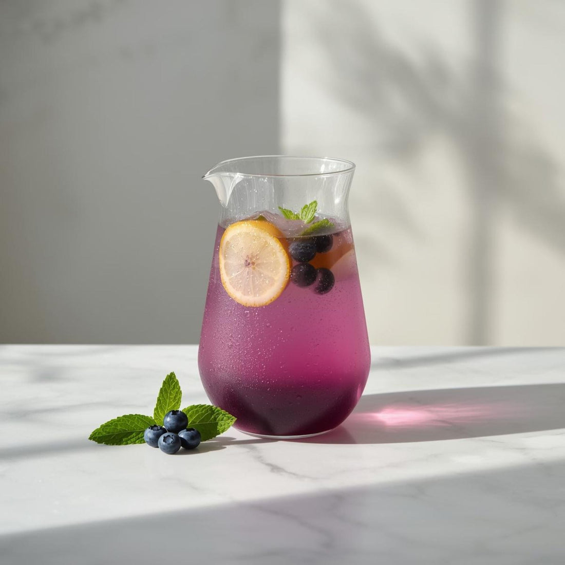 iced purple tea in glass pitcher for summer refreshment