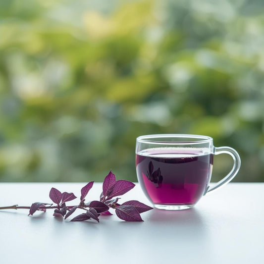 Purple tea leaves beside a glass cup of violet tea highlighting natural anthocyanin pigmentation