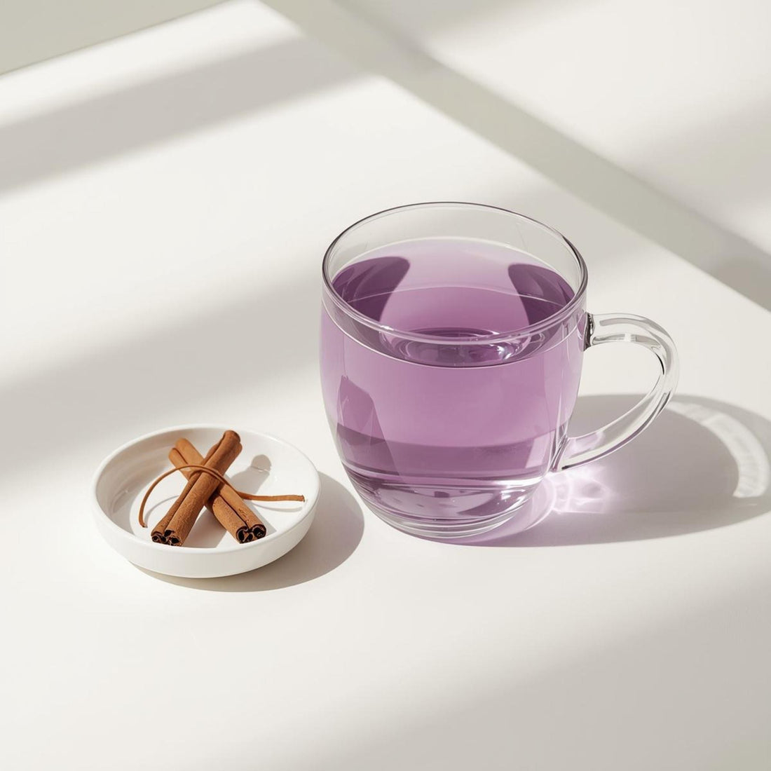 Glass cup of purple tea with cinnamon sticks showing balanced spice infusion and antioxidant-rich color