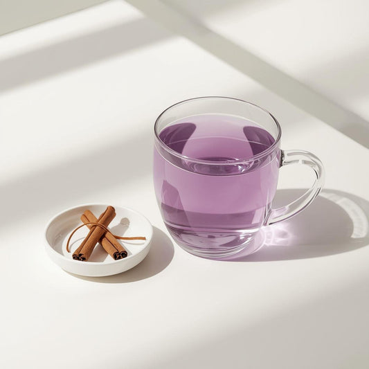 Glass cup of purple tea with cinnamon sticks showing balanced spice infusion and antioxidant-rich color